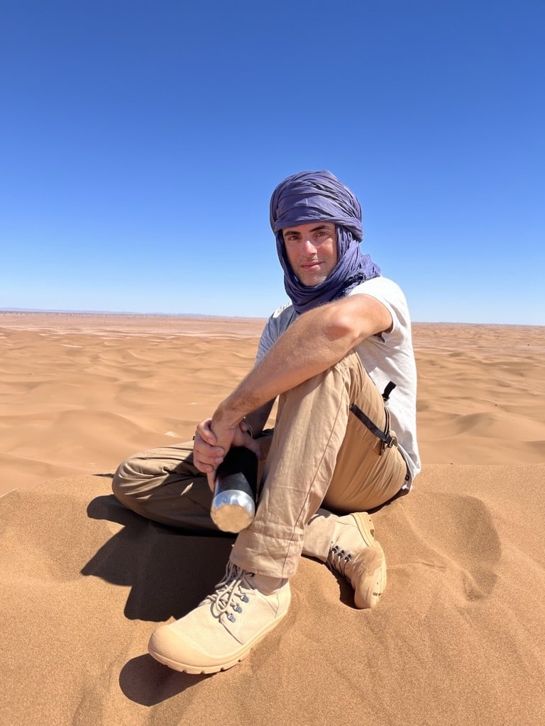 oyageur équipé pour une marche dans le désert marocain avec foulard, chaussures de marche et gourde