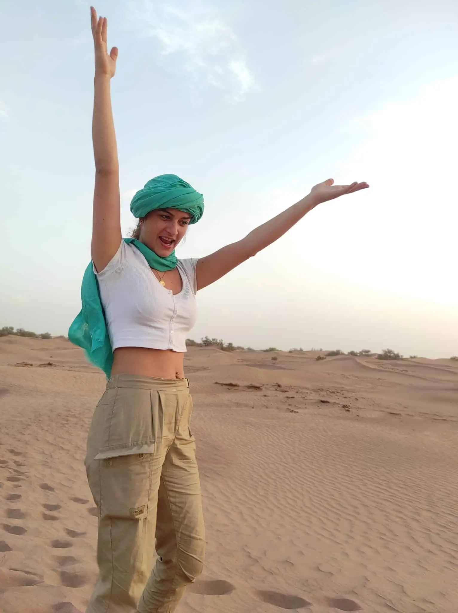 Joie et liberté – Retraite spirituelle au Maroc Jeune femme rayonnante dans le désert lors d’un voyage spirituel au Maroc